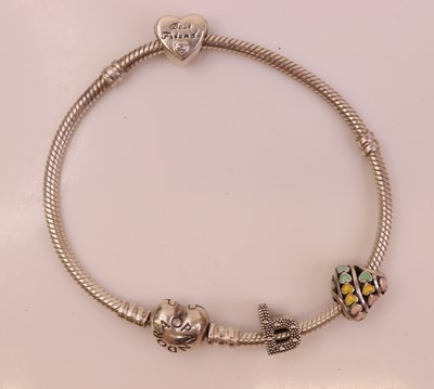 Lot 301 - A Pandora silver bracelet with three charms,...
