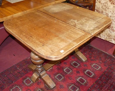 Lot 1328 - An early 20th century oak draw-leaf dining...