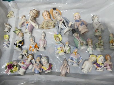 Lot 548 - A collection of porcelain pin cushion dolls,...