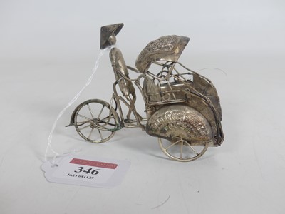 Lot 346 - An eastern white metal model of a man driving...