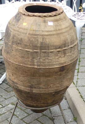 Lot 1441 - A large rustic terracotta olive jar, raised on...