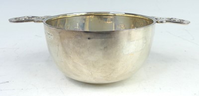 Lot 114 - An Arts & Crafts twin handled silver porringer,...