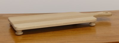 Lot 1517 - A contemporary oak cheeseboard on bun feet,...