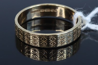 Lot 355 - A modern 9ct gold engraved wedding band,...