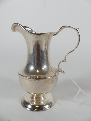 Lot 295 - A white metal cream jug of helmet shape having...
