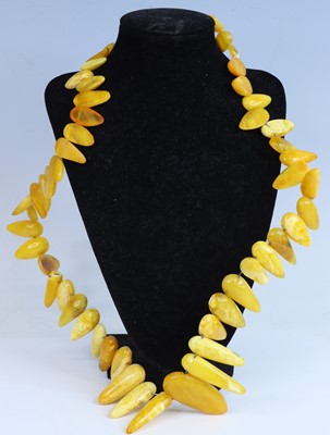 Lot 405 - A faux butterscotch amber necklace, arranged...