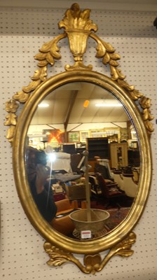 Lot 1222 - A floral decorated gilt wood oval wall mirror,...