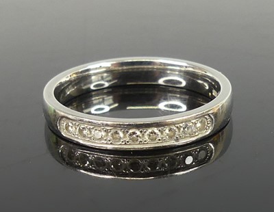 Lot 2504 - A platinum diamond half eternity ring,...