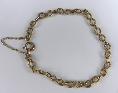 Lot 2571 - A yellow metal textured figure-of-eight...