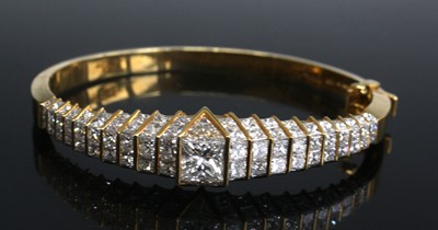 Lot 2613 - An 18ct gold and diamond set bangle, arranged...