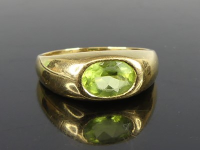 Lot 2636 - A yellow metal peridot dress ring, comprising...