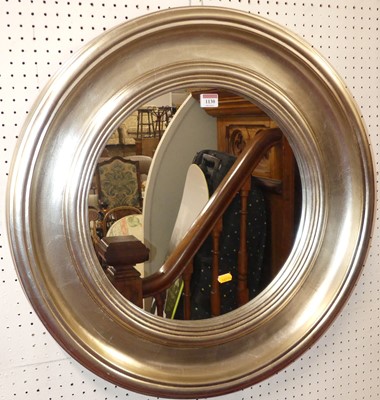 Lot 1130 - A contemporary silvered circular wall mirror,...