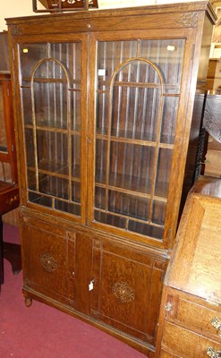 Lot 1223 - A 1930s oak freestanding bookcase, having twin...